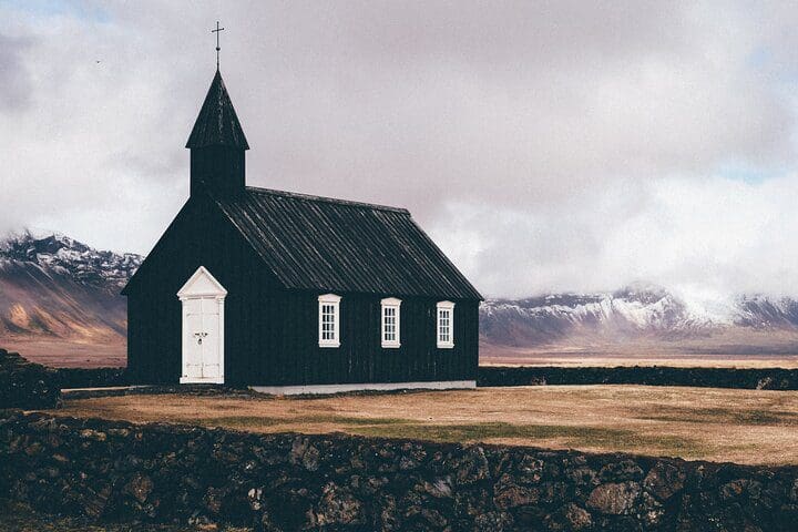 A historic black church, as seen on Small-Group Day Tour of Snaefellsnes Peninsula Natural Park.