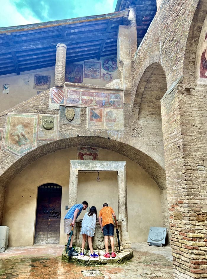 A family explores a small Tuscan village while on a tour.