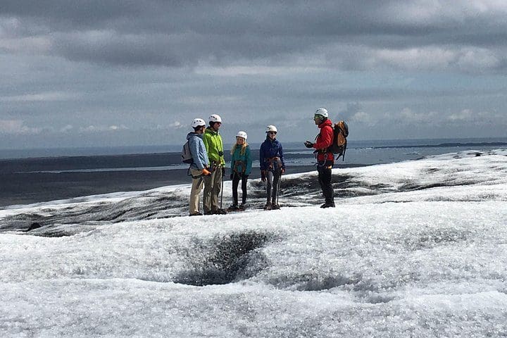 A group of people hikes across a glacier, while on a Vatnajökull Glacier Walk from Hali.