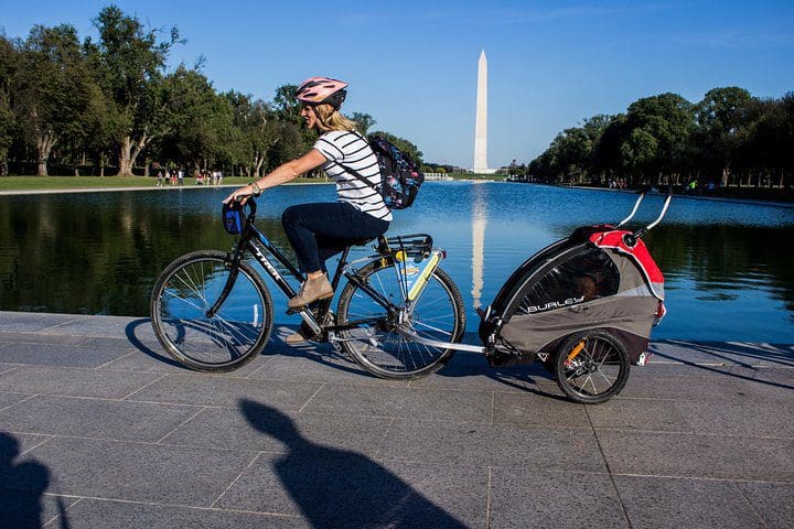 A mom pulls a buggies behind a bike while on the Washington DC Monuments Bike Tour.