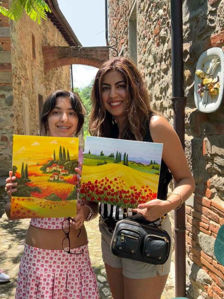 A mom and her young daughter show off their art pieces from a Tuscan art class, one of the best tours and classes in Tuscany with kids.