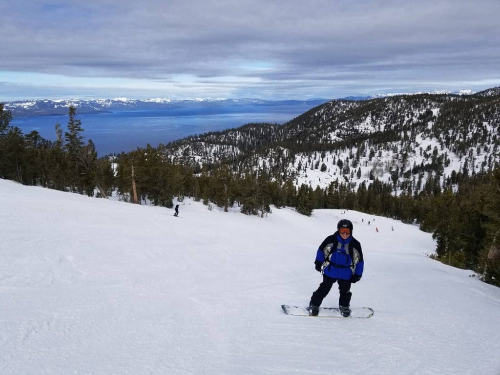 A man snowboards down a run at Heavenly Resort, one of the best places to visit in California with kids!