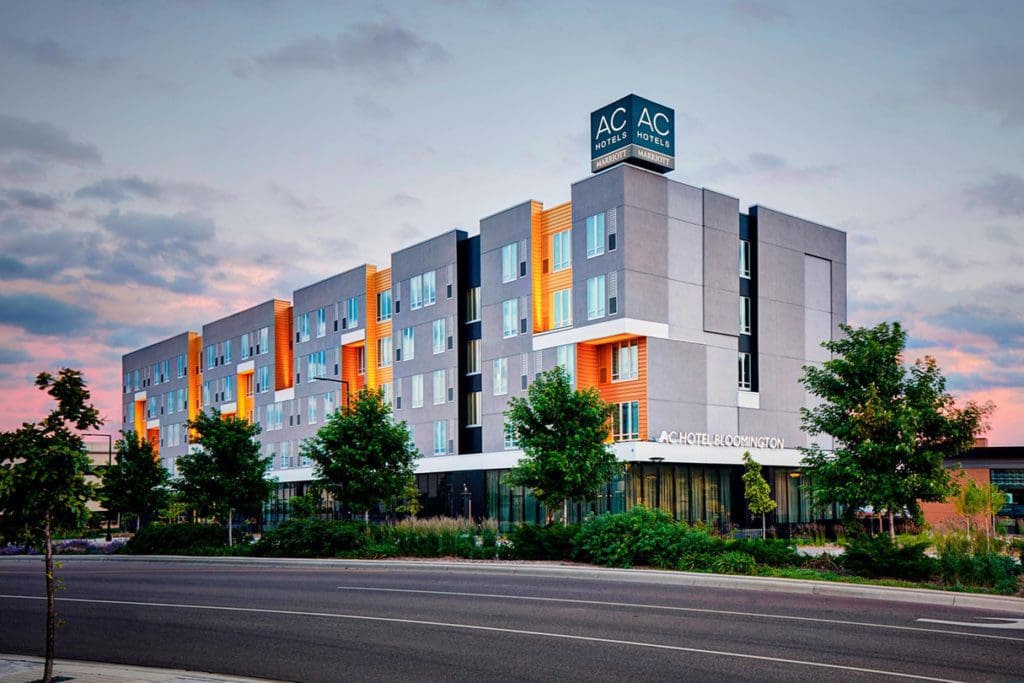 The exterior of AC Hotel by Marriott Bloomington Mall of America, lit up at night.