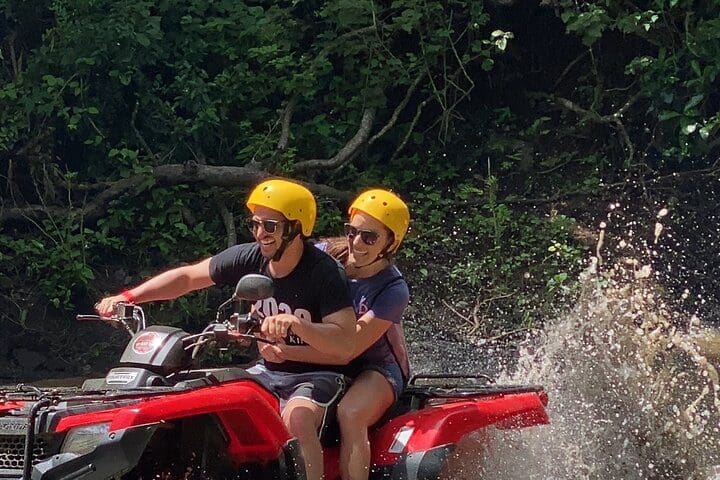 A couple ATVs through the mud on the ATV Beach and Mountain Tour.