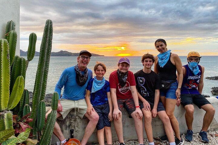 A family sits together enjoying a day on the ATV Beach and Mountain Tour.