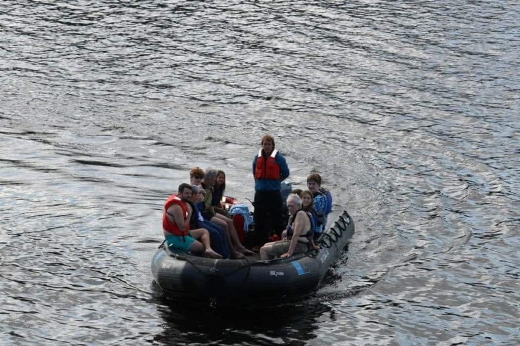 A family rides in a zodiac around the Alaska fjords.