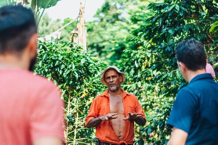 A farmer gives a lesson to a family on the Chocolate and Farm Tour with Local Tico Family.
