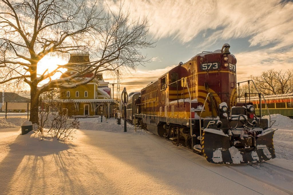 A Conway Scenic Railroad train parked in the tracks during a winter's ride near North Conway, one of the best places for a White Christmas in the United States for families.