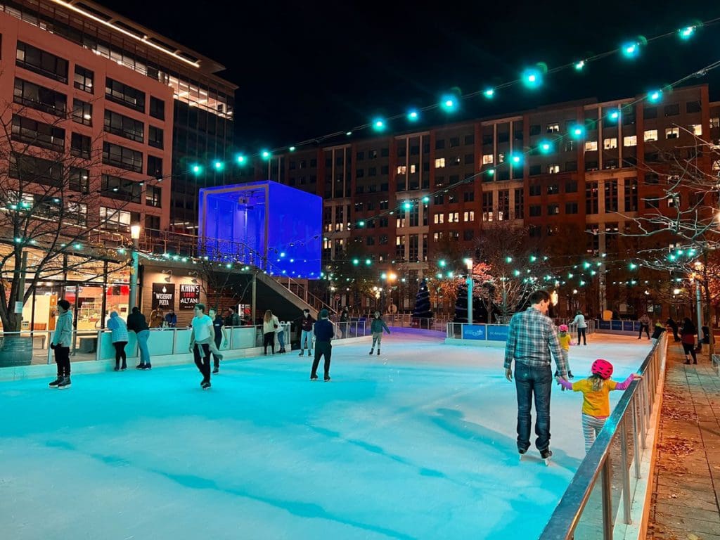 Families skating around an ice rink in Washington DC, one of the best places near NYC to ring in the New Year with kids.