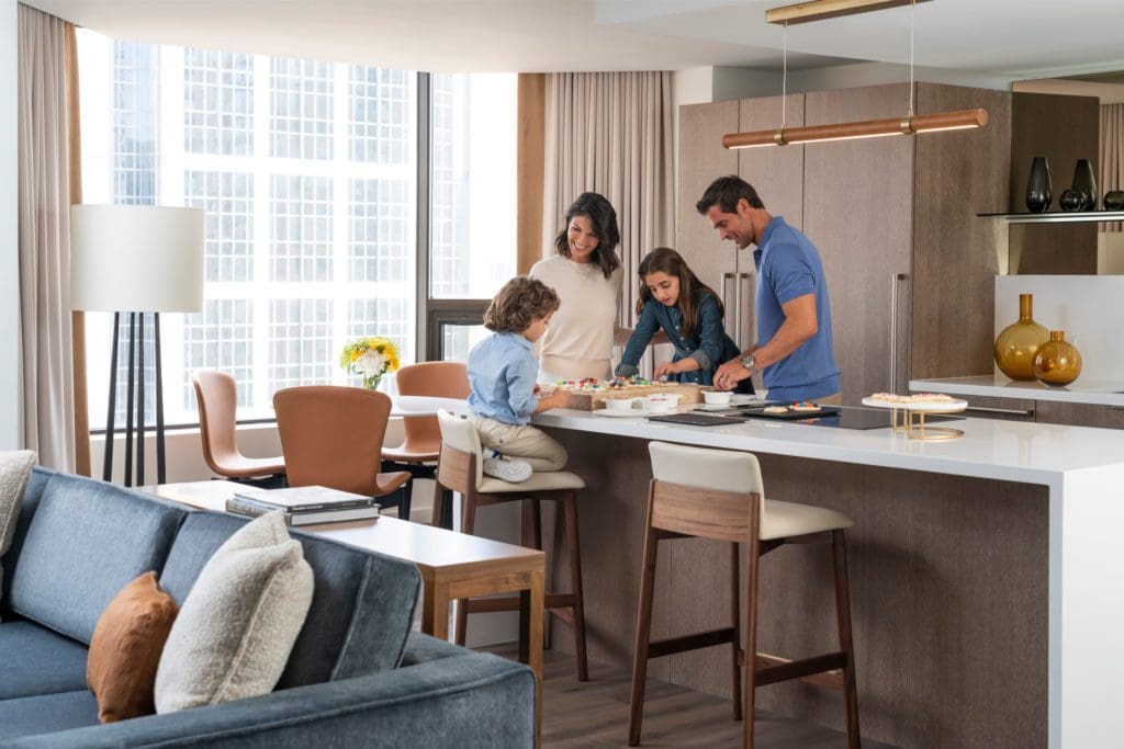 A family of four eats together at a counter in a suite at Four Seasons Hotel Houston.