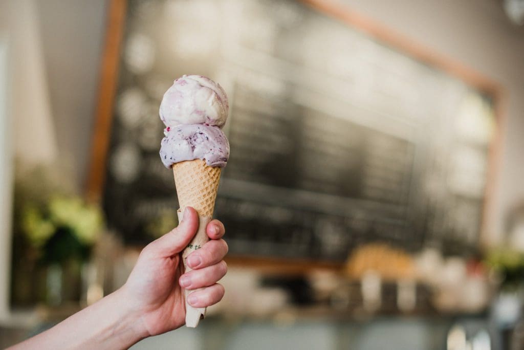 A hand holds out an ice cream cone at High Point Creamery.