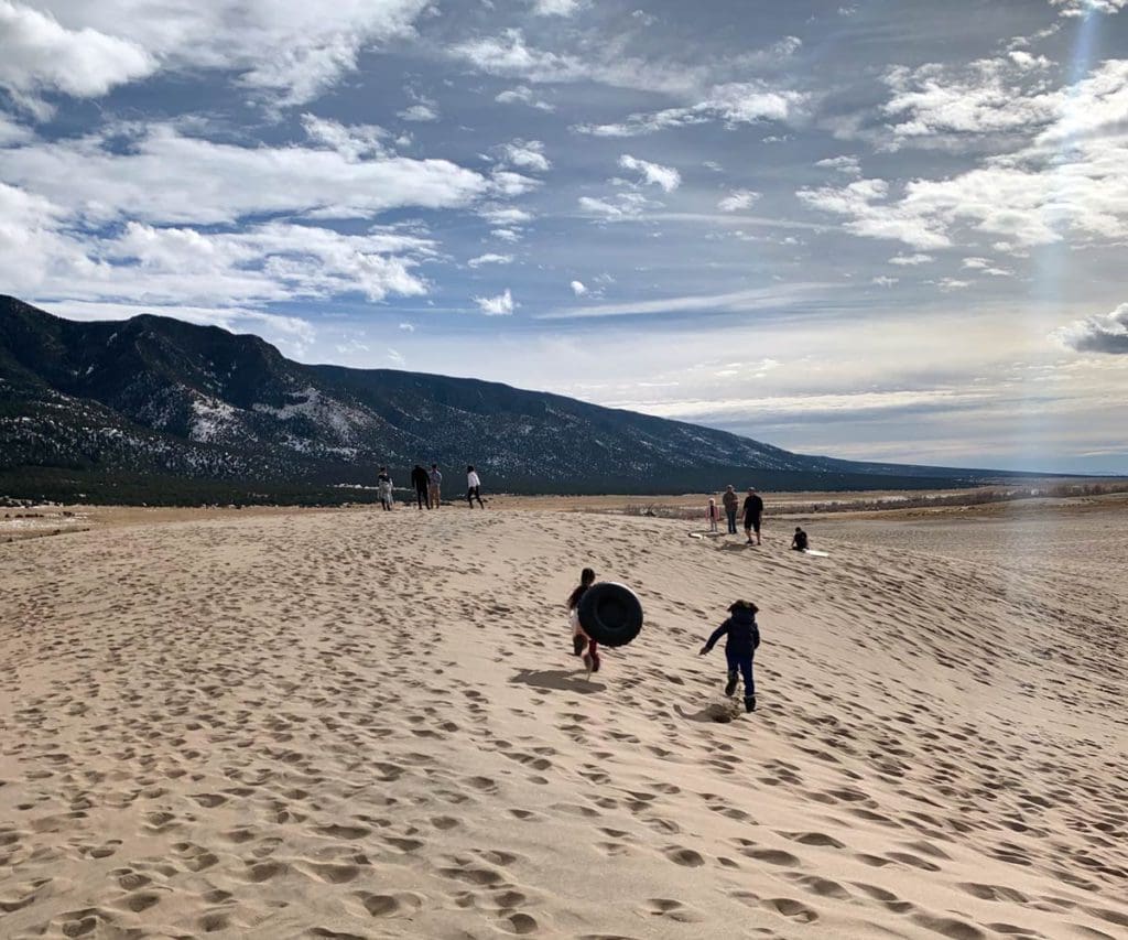 Kids play in Great Sand Dunes National Park in Colorado. It's one of the best affordable spring break destinations in the U.S. for families!