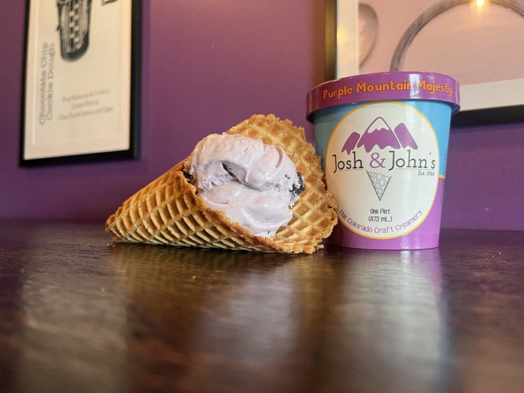 An ice cream cone laid by a pint of ice cream from Josh & John’s.