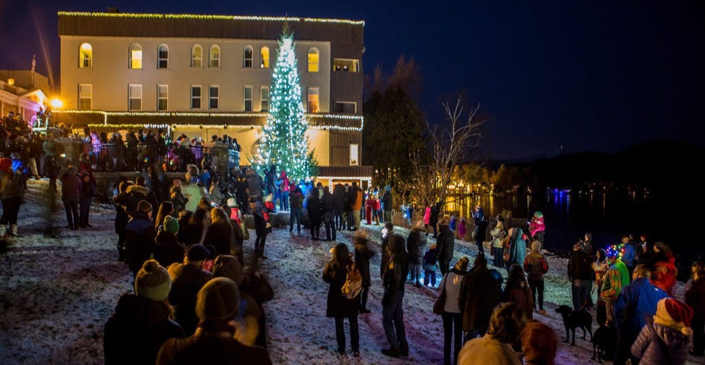 A crowd of people gather for a Christmas tree lighting in Lake Placid.