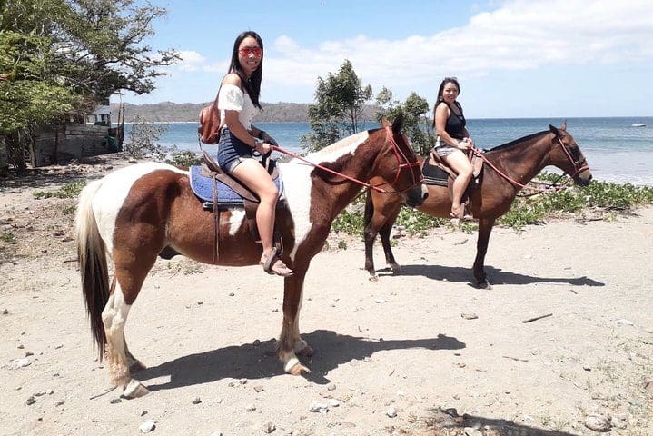 Two people on horseback enjoy a lovely day on the 1.5 Hours Private Horseback Riding Tour in Playa Conchal.