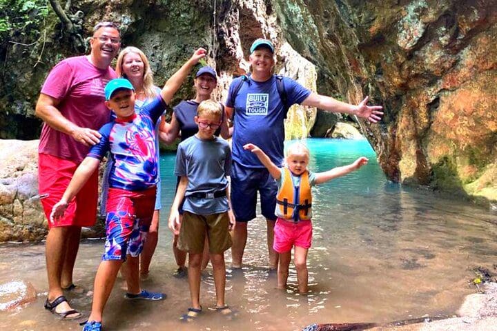 A family poses together, while enjoying the Private La Leona Waterfall Adventure Hike (Self-Drive) tour.