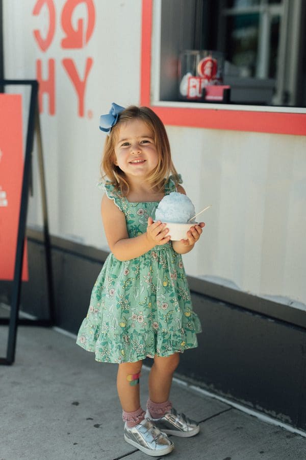 A young girl enjoys a blue dessert from Punch Buggy Shave Ice.