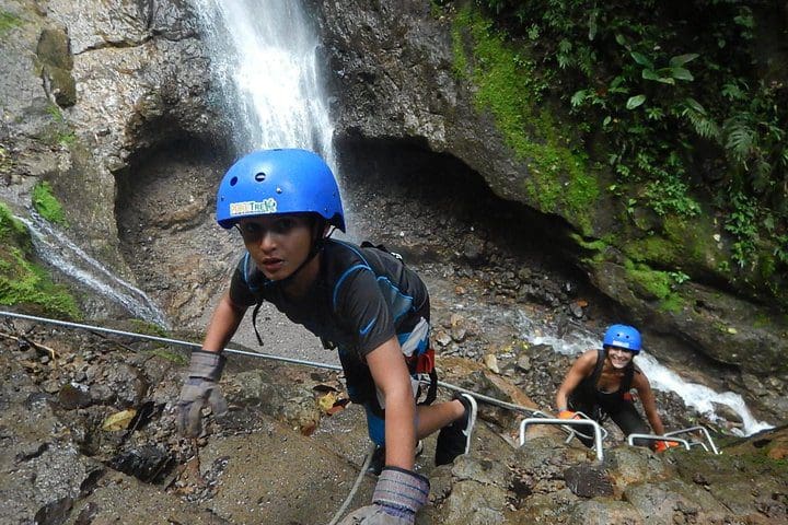 Kids rappel down a cliffside on the Pure Trek Canyoning and Waterfall Rappelling Tour in La Fortuna.