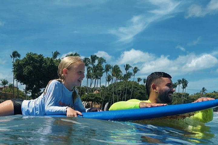 An instructor teaches a child to surf with the Surf Lessons in Tamarindo, Costa Rica tour.