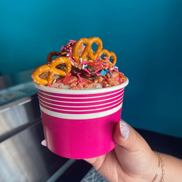 A hand holds out a fun ice cream dish at The Cake Bar, one of the best dessert spots in Denver with kids.