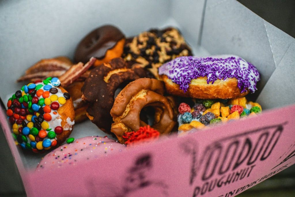 A box filled with colorful Voodoo Doughnuts.