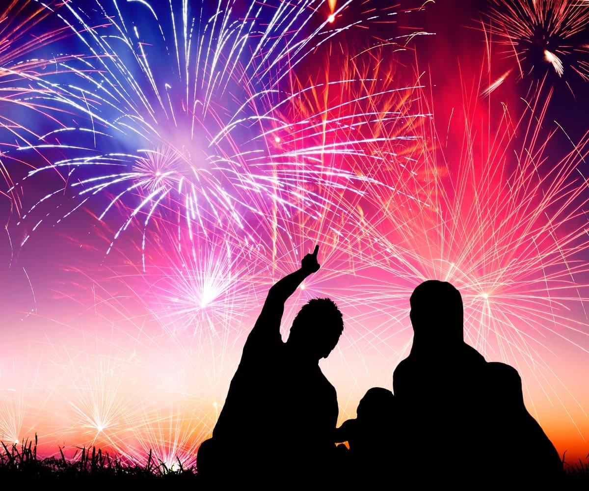 A family enjoys watching New Year's Eve fireworks together.