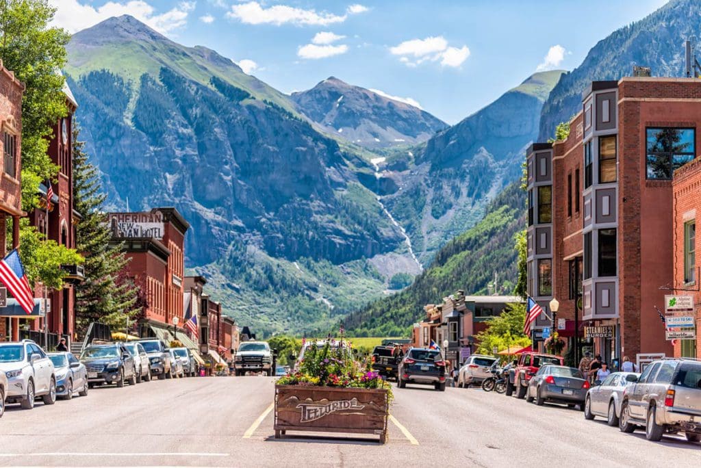 Downtown Telluride, one of the best weekend getaways near Denver for families, in the summer with mountains in the distance. 