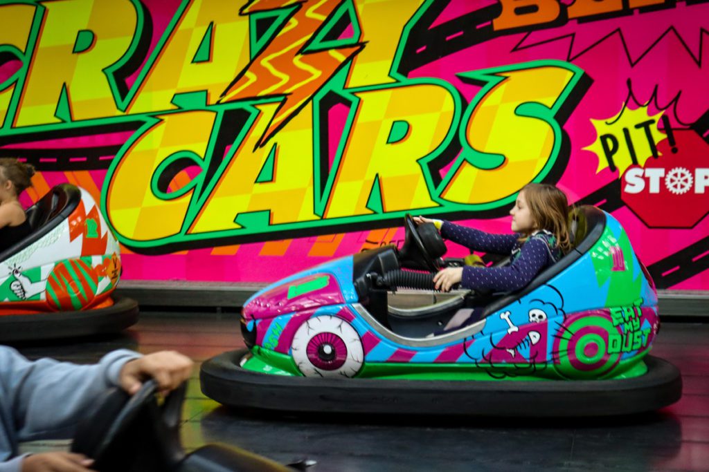 A young girl plays bumper cars at Nickelodeon Universe.