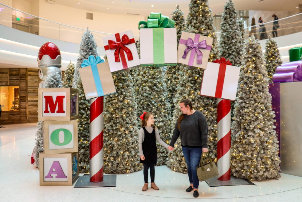 A mom and her young daughter stand amongst holiday decor at the Mall of America.