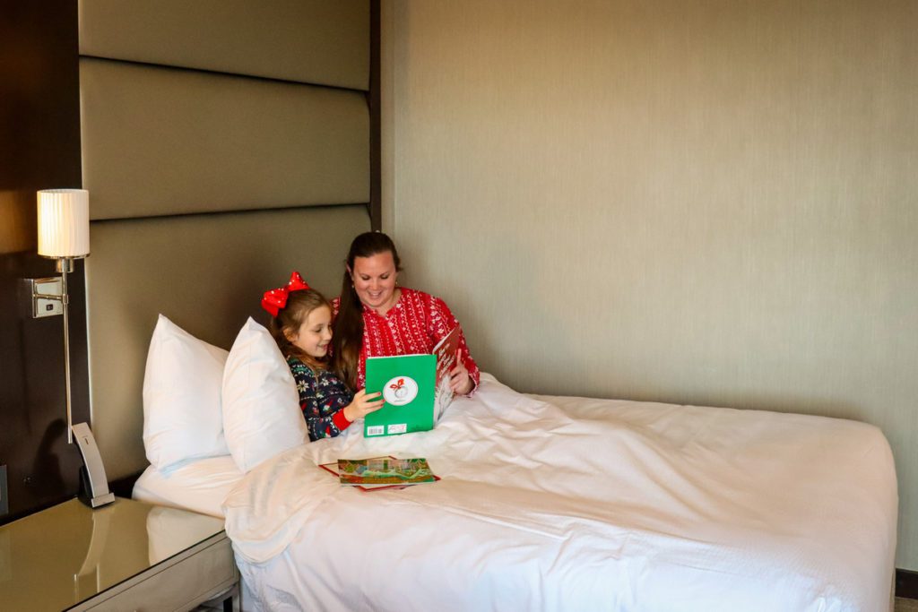 A mom and her young daughter read Christmas books in bed, while staying at the JW Marriott Minneapolis Mall of America.