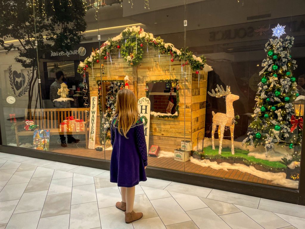 A young girl enjoys a window display decorated for Christmas at the Mall of America.
