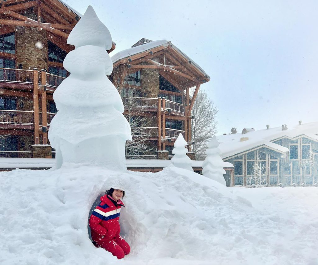 A young boy building a snowman during the winter in Jackson Hole