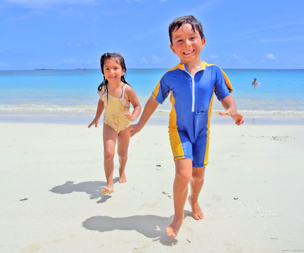 Two kids running on the beach in the Dominican Republic, one of the best affordable Caribbean islands for families 