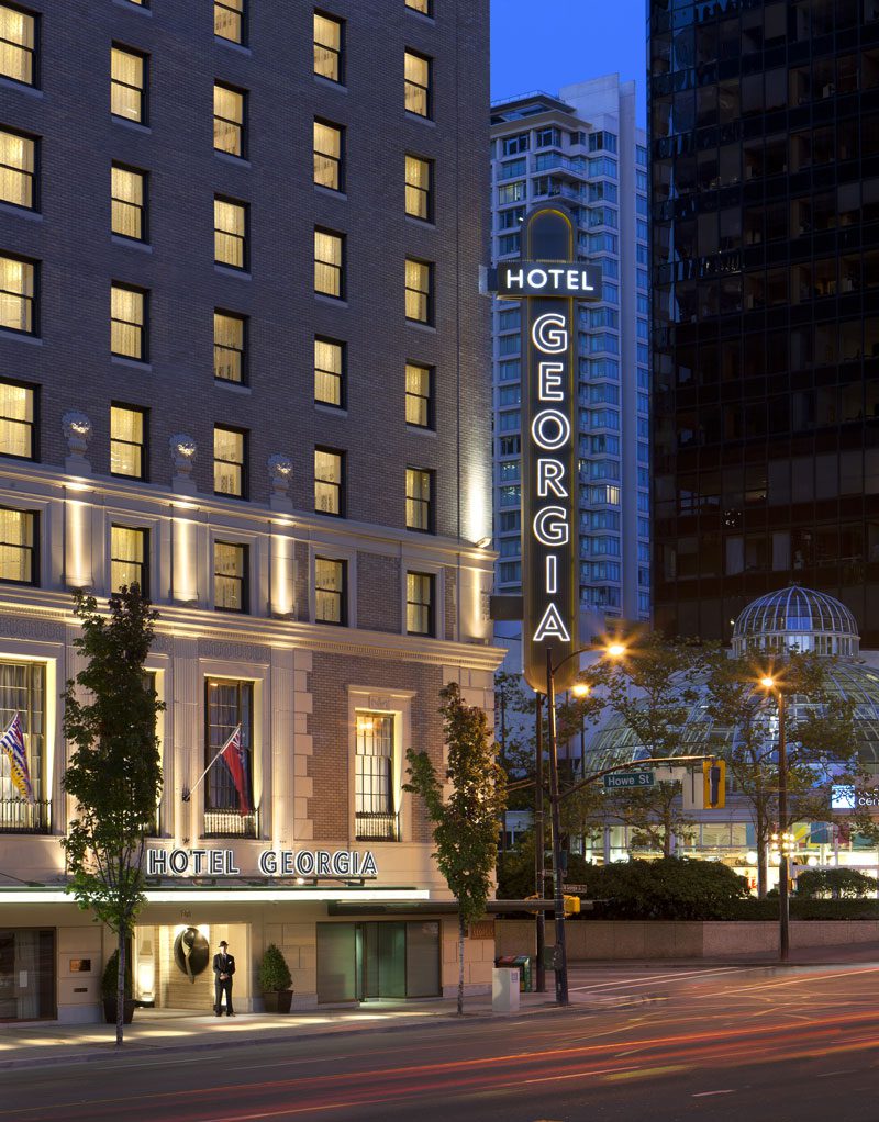 An exterior, nighttime view of the Rosewood Hotel Georgia, one of the best hotels in Vancouver for families.