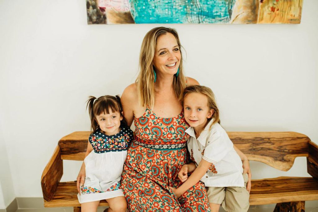 A mother and her two children sitting on a bench at SoMos Retreats in Oaxaca