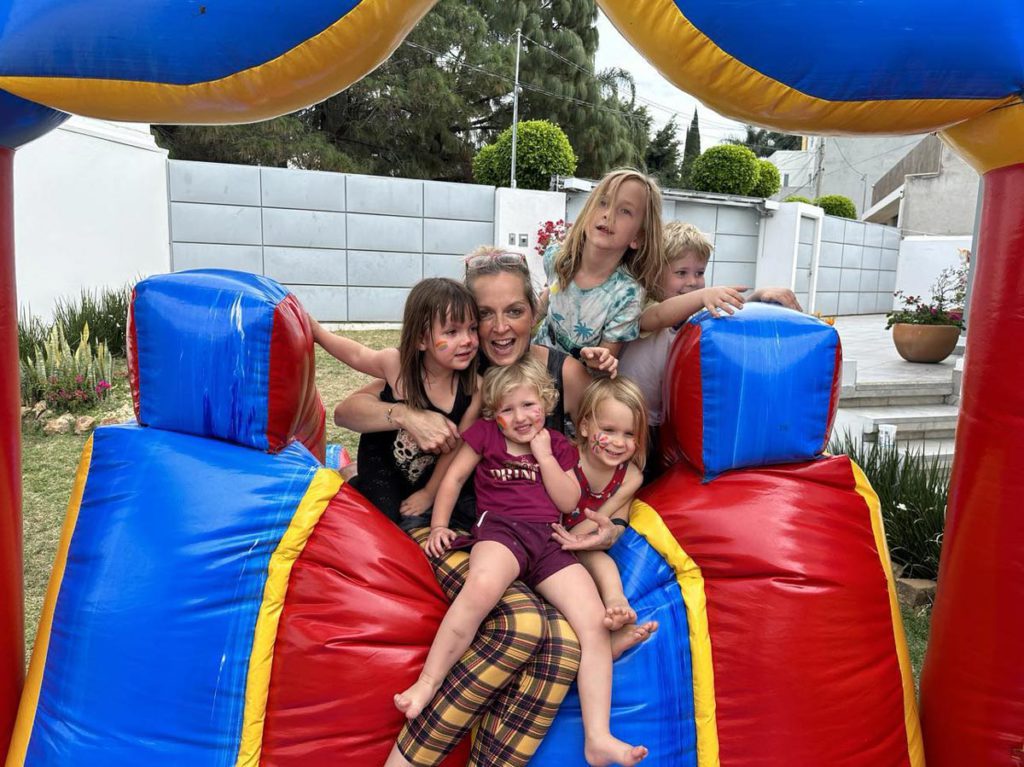 A mother and children on a bouncy slide at SoMos Retreats in Oaxaca, Mexico.