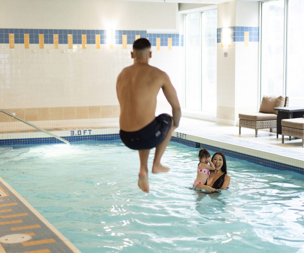 A family enjoying the pool at the Vancouver Marriott Pinnacle Downtown, one of the best hotels in Vancouver for families. 