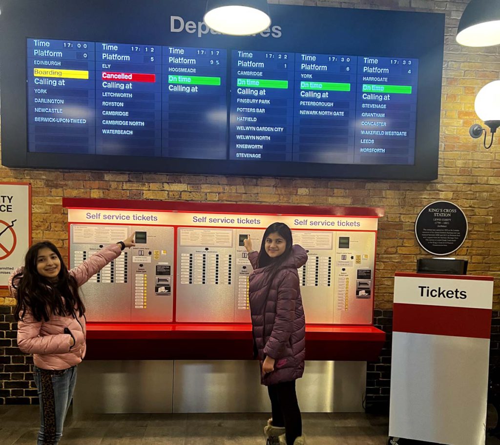 Three young girls standing by the self-service tickets at the Harry Potter Store in NYC.