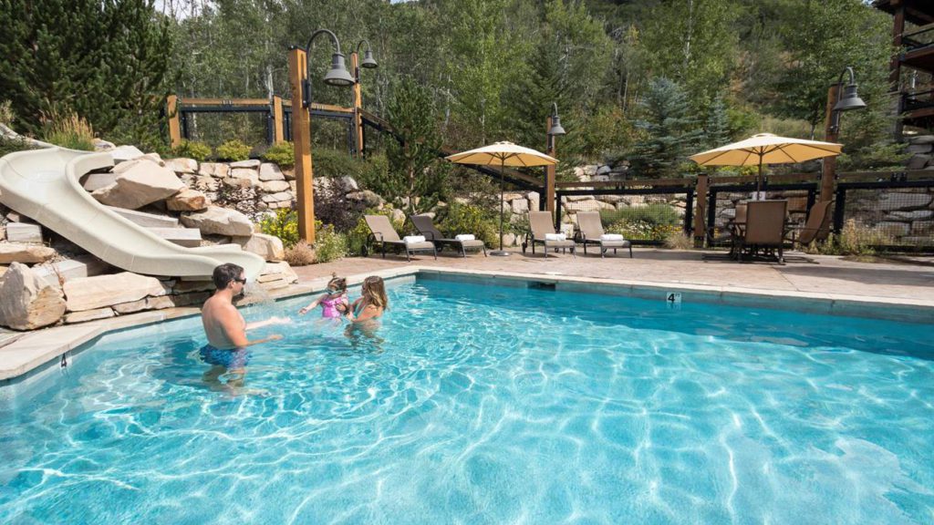 A family playing in the outdoor pool at the Silver Baron Lodge in Deer Valley