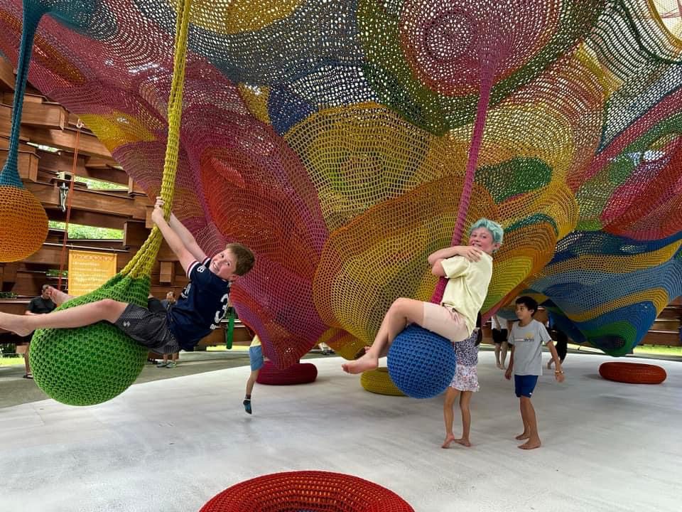 Two kids swinging on an artwork at the Hakone Open Air Museum, one of the best places to visit in Japan with kids.