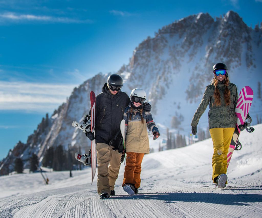 A family walking with their skis at Snowbasin Ski Resort in Utah, one of the best ski resorts for families.
