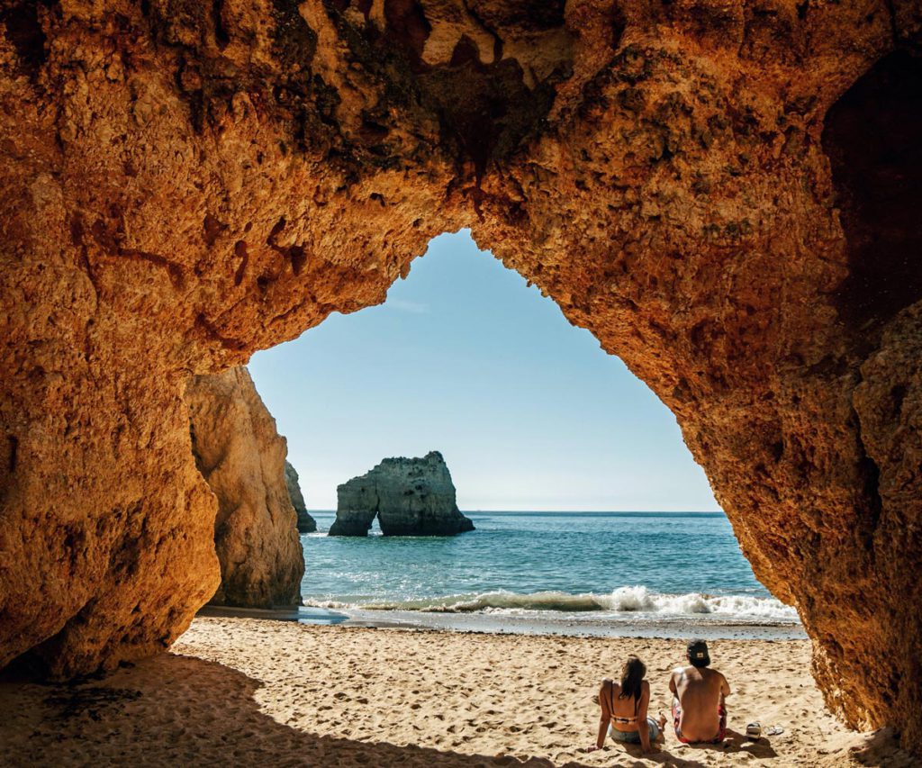 A couple relaxing on the beach in Big Sur, one of the best weekend getaways from San Francisco for families. 