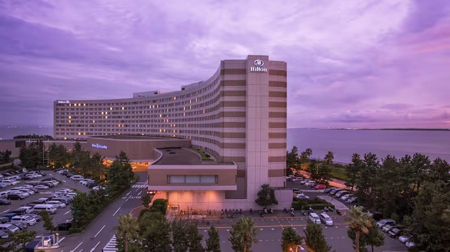 An exterior view of the Hilton Tokyo Bay Hotel at sunset.