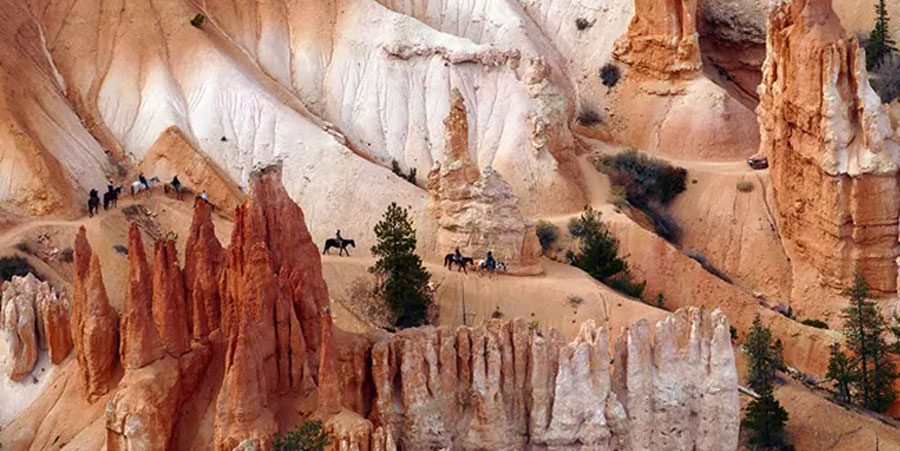 A group of riders on horseback in Bryce Canyon, Utah. It's one of the best bucket list experiences in the United States for your family. 