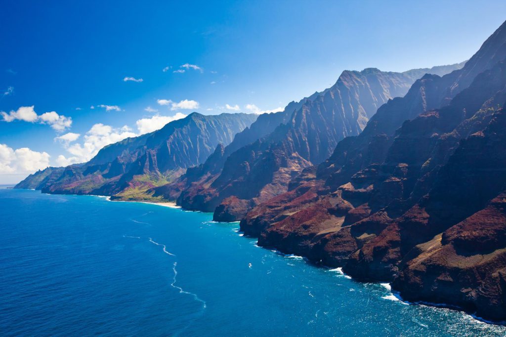 A view of the mountains and emerald blue waters of the Na Pali Coast in Hawaii. 