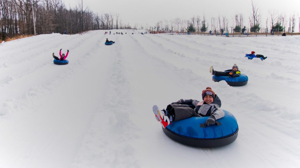 Kids snow tubing at Montage Mountain, one of the best places to go snow tubing in The Poconos with kids.