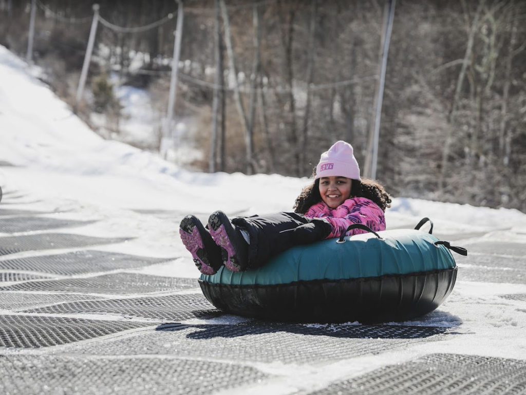 A young girl snow tubing at Shawnee Mountain Ski Area, one of the best places to go snow tubing in the Poconos with kids.