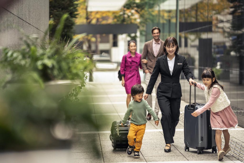 A family walking with their luggage to the Four Seasons Tokyo.