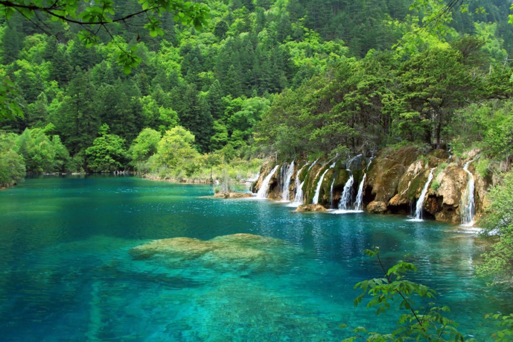 Turquoise green water and waterfalls in Jiuzhaigou National Park, one of the best places to visit in China with kids.