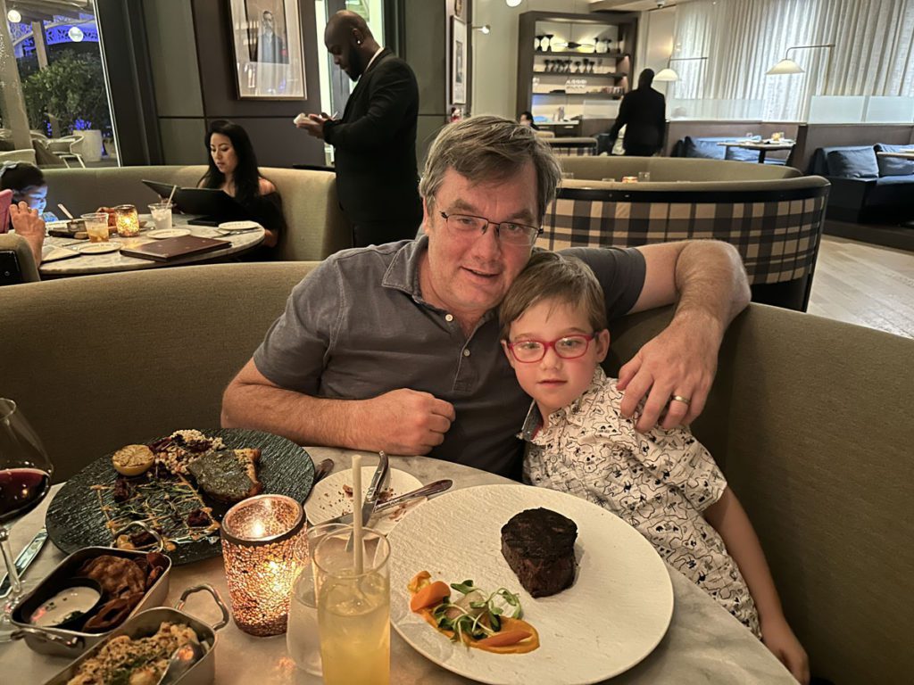 A father and son eating at one of the on-site restaurants for families at Baha Mar Resort in the Bahamas.